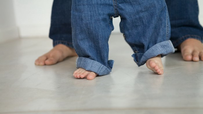 Baby and adult feet in jeans