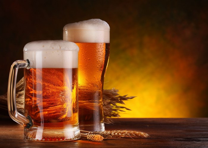 Two mugs of beer with wheat stalks