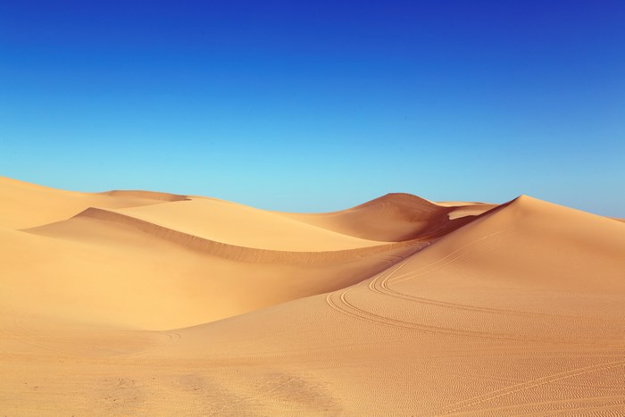 Desert dunes under a clear blue sky