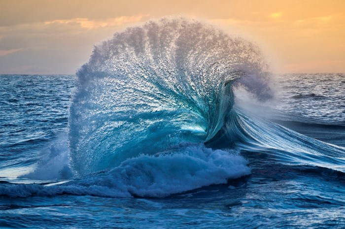 Ocean wave crashing at sunset