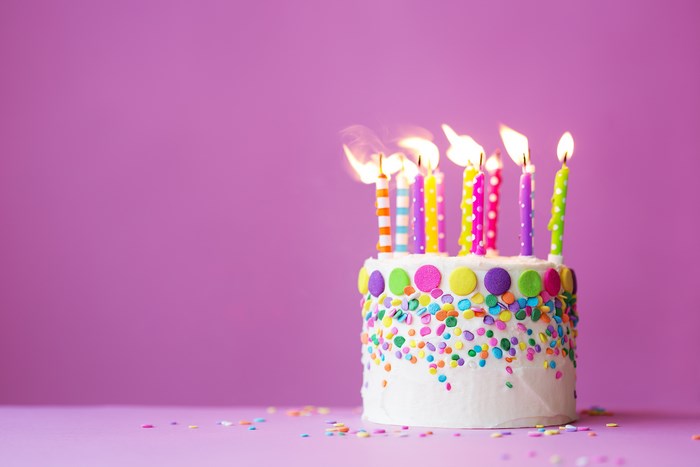 Birthday cake with lit candles and sprinkles