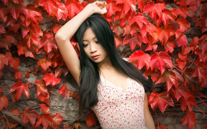 Woman Posing Among Vibrant Red Autumn Leaves