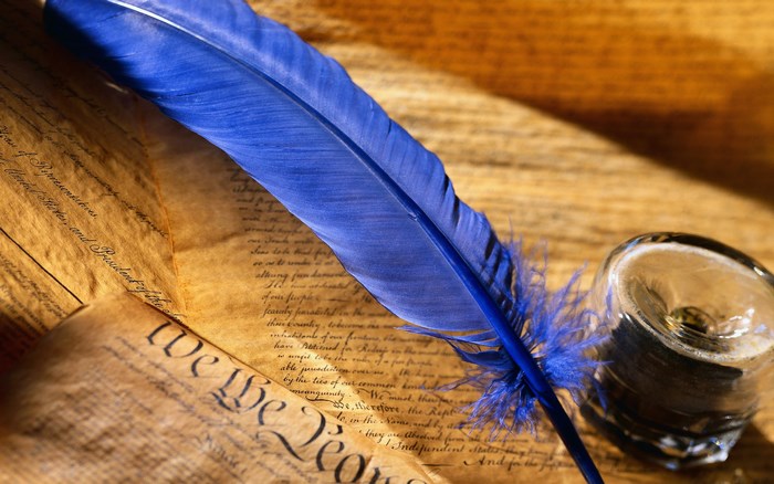Blue feather quill on historical document