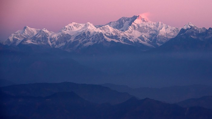 Snow-capped mountains under a pink sky