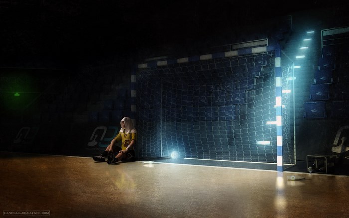 Girl sitting in front of handball goal