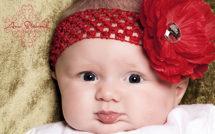 Cute baby girl with red headband and flower
