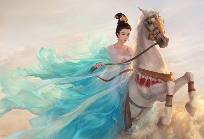 Woman in flowing dress riding a white horse