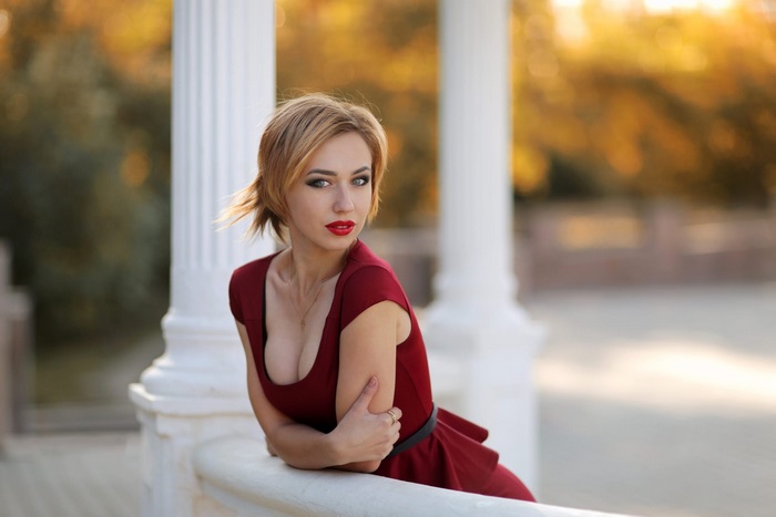 Young Woman in Red Dress by White Columns