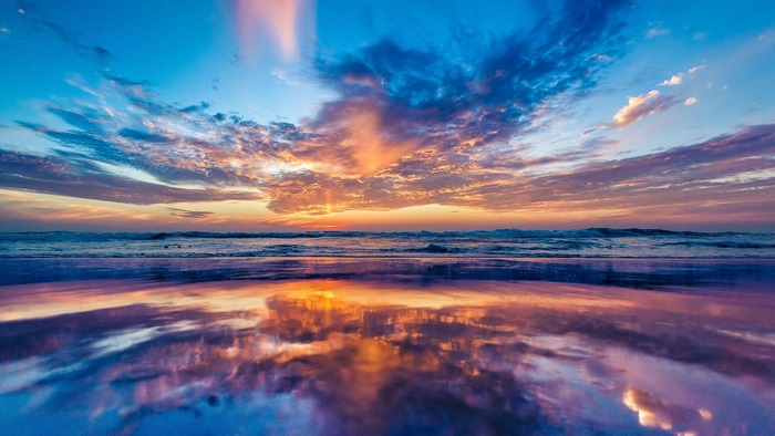 Ocean sunset with colorful clouds and reflection
