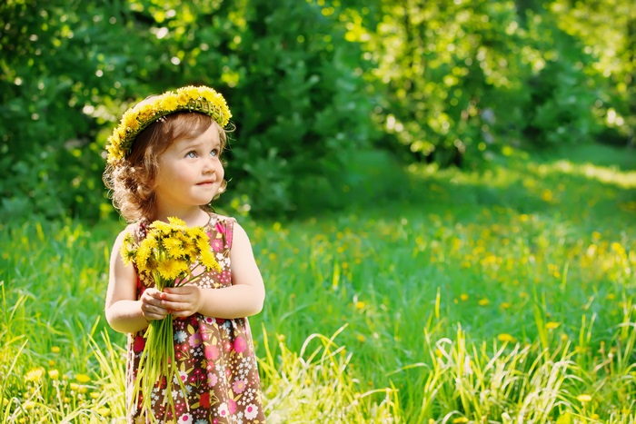 Cute girl with dandelion crown and bouquet