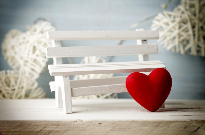 Red heart on a white bench with white hearts