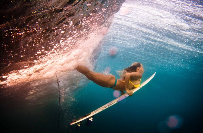 Surfer girl underwater in a wave 4K
