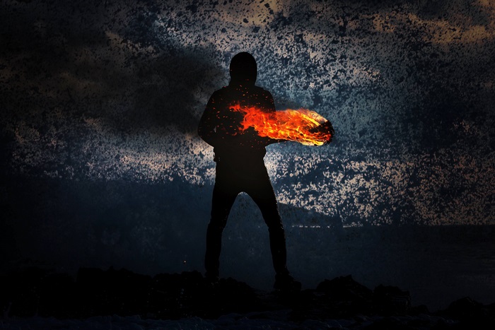 Silhouette of a person holding fire