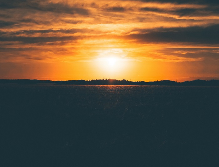 Sunset over a field with clouds