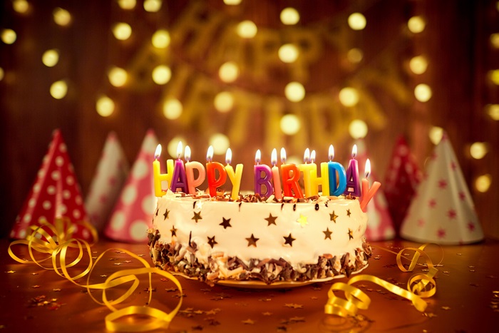 Birthday cake with candles and party hats