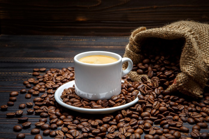 Coffee cup and beans on wooden table 4K