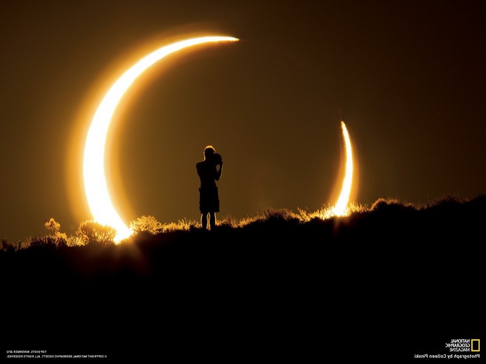 Solar eclipse with photographer silhouetted against the sun