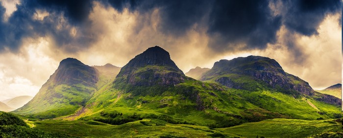 Three Sisters mountains in Glencoe, Scotland under dramatic clouds