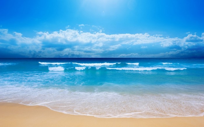 Beach with waves and blue sky