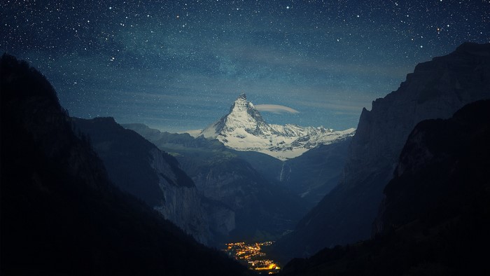 Matterhorn mountain at night with stars and village