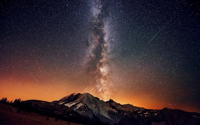 Milky Way over snow-capped mountains at night