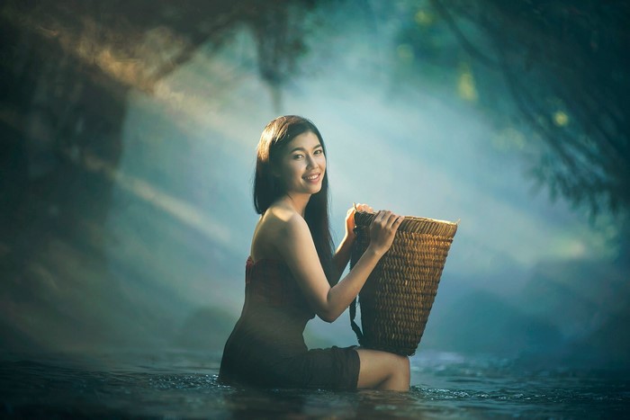 Asian woman with basket in water
