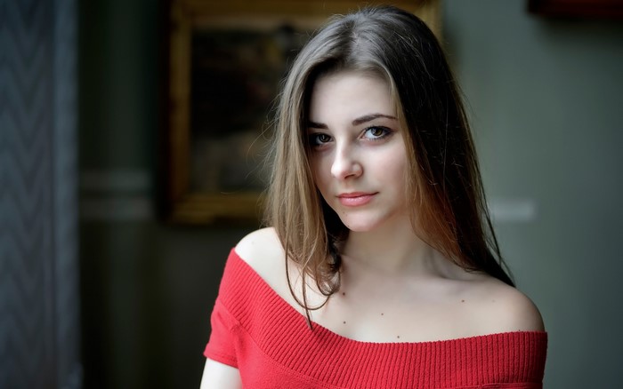 Young woman with brown hair wearing a red top