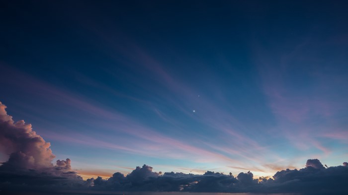 Two bright stars in a twilight sky with clouds