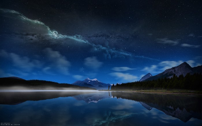 Lake at night with mountains and stars