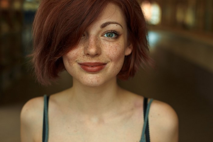 Redhead woman with freckles and green eyes looking at viewer