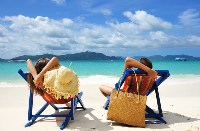 Couple relaxing on beach chairs by the sea