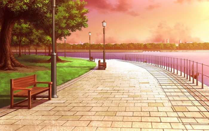 Park pathway along a river at sunset
