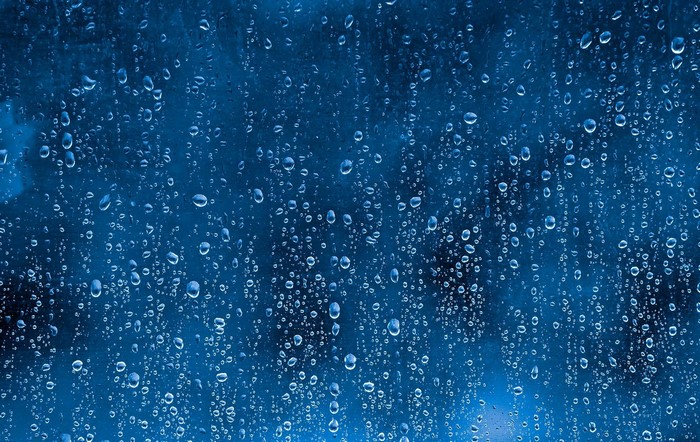 Water drops on a blue textured surface