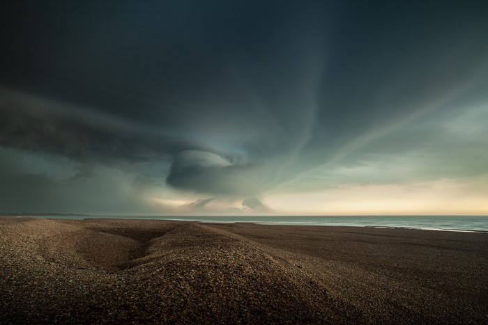 Stormy sky over a pebble beach and the sea
