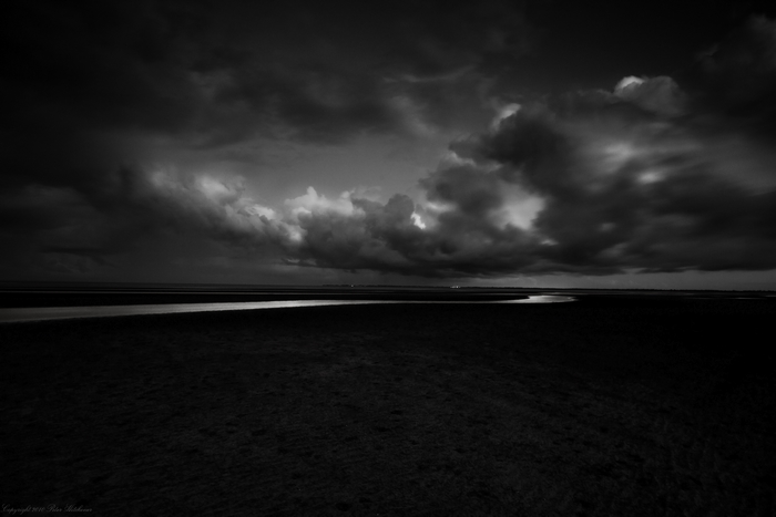 Monochrome landscape with dark clouds and a river