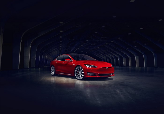 Red Tesla Model S electric car in a dark tunnel