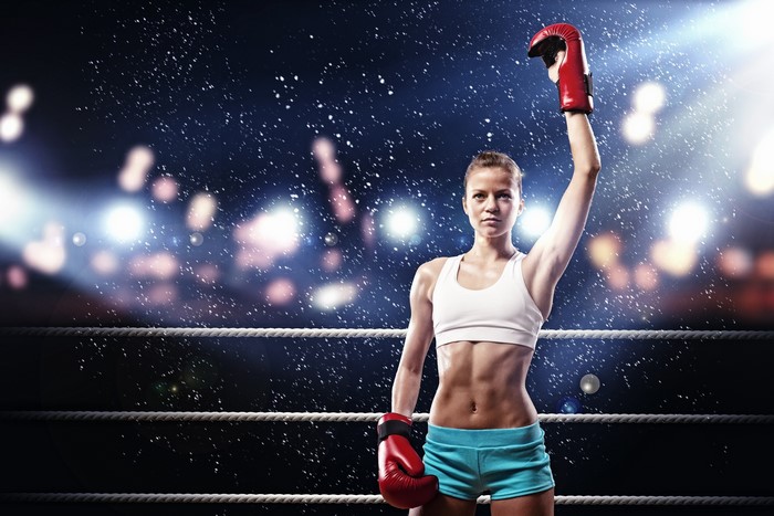 Female boxer with arm raised in victory