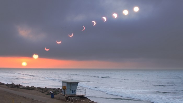 Solar eclipse over the ocean at sunset