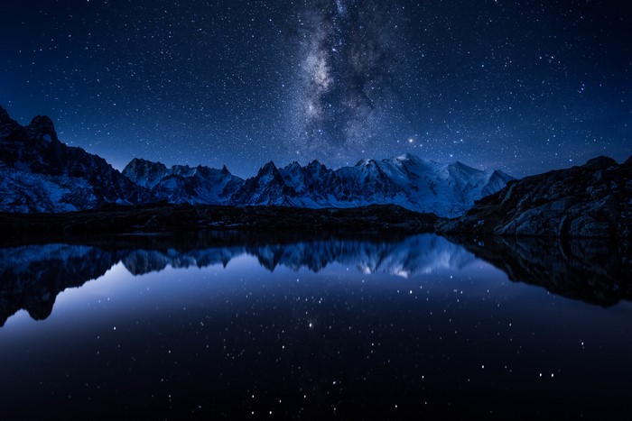 Milky Way over snow-capped mountains reflected in a lake