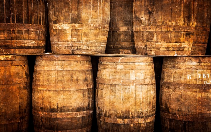 Stacked wooden whisky barrels in a cellar
