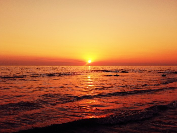 Sunset over the ocean with waves