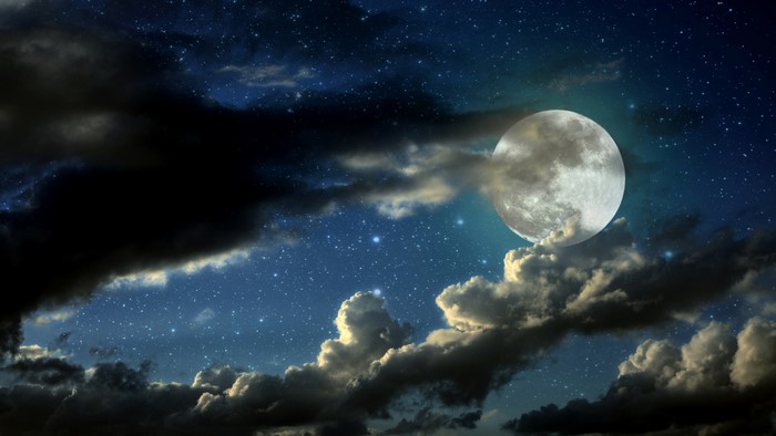 Full moon and stars in a cloudy night sky