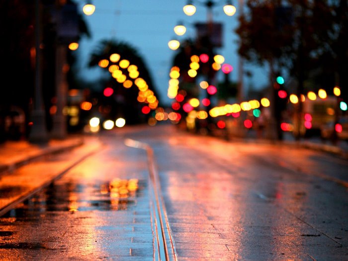 City street at night with wet pavement and bokeh lights