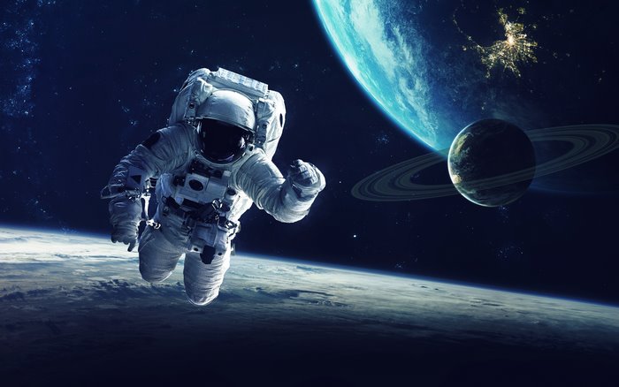 Astronaut floating in space near planets