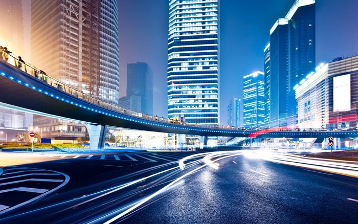City street with overpass and light trails at night