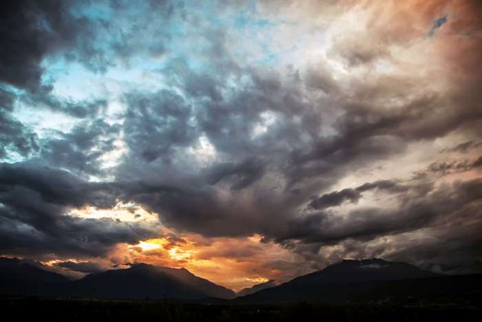 Dramatic clouds over mountains at sunset 4K