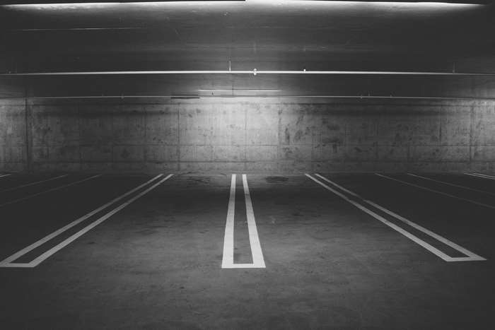 Empty underground parking garage with concrete walls and floor markings
