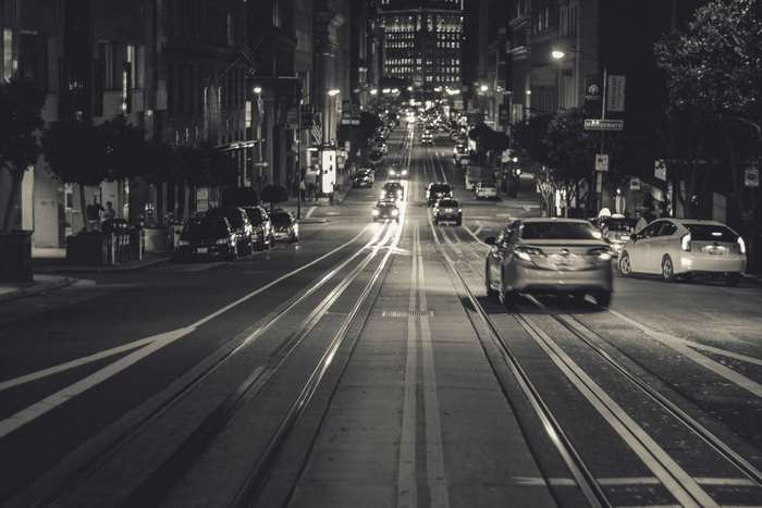 San Francisco street at night with cars and tram tracks