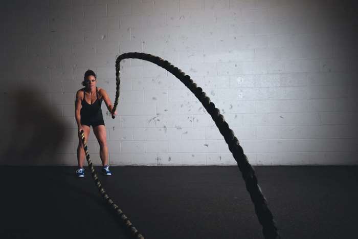 Woman training with battle ropes in a gym