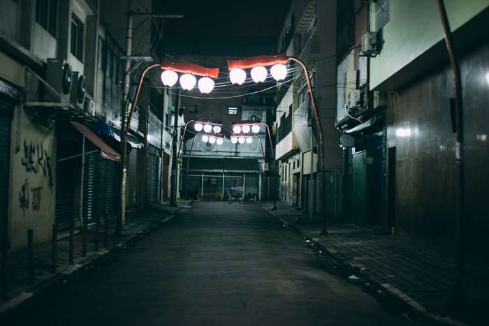 Empty city alley at night with street lights